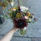 A small custom vase arrangement with white, red and yellow flowers.